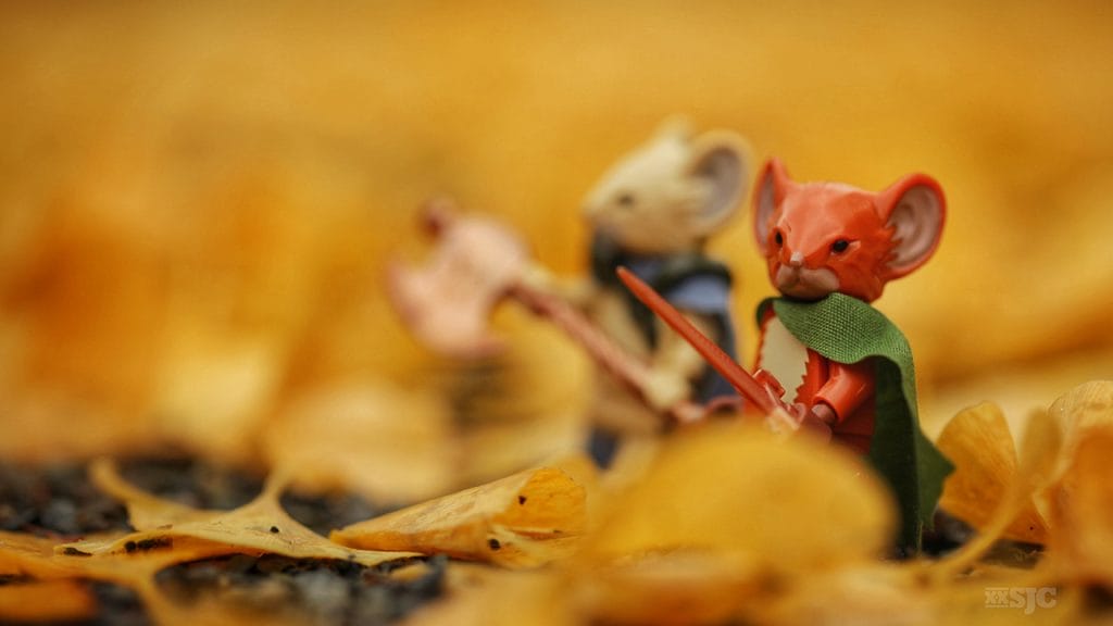 two lego mouse guard figures outfitted with their weapons walk through the fallen leaves as if in a sea of gold. Image by Shelly Corbett